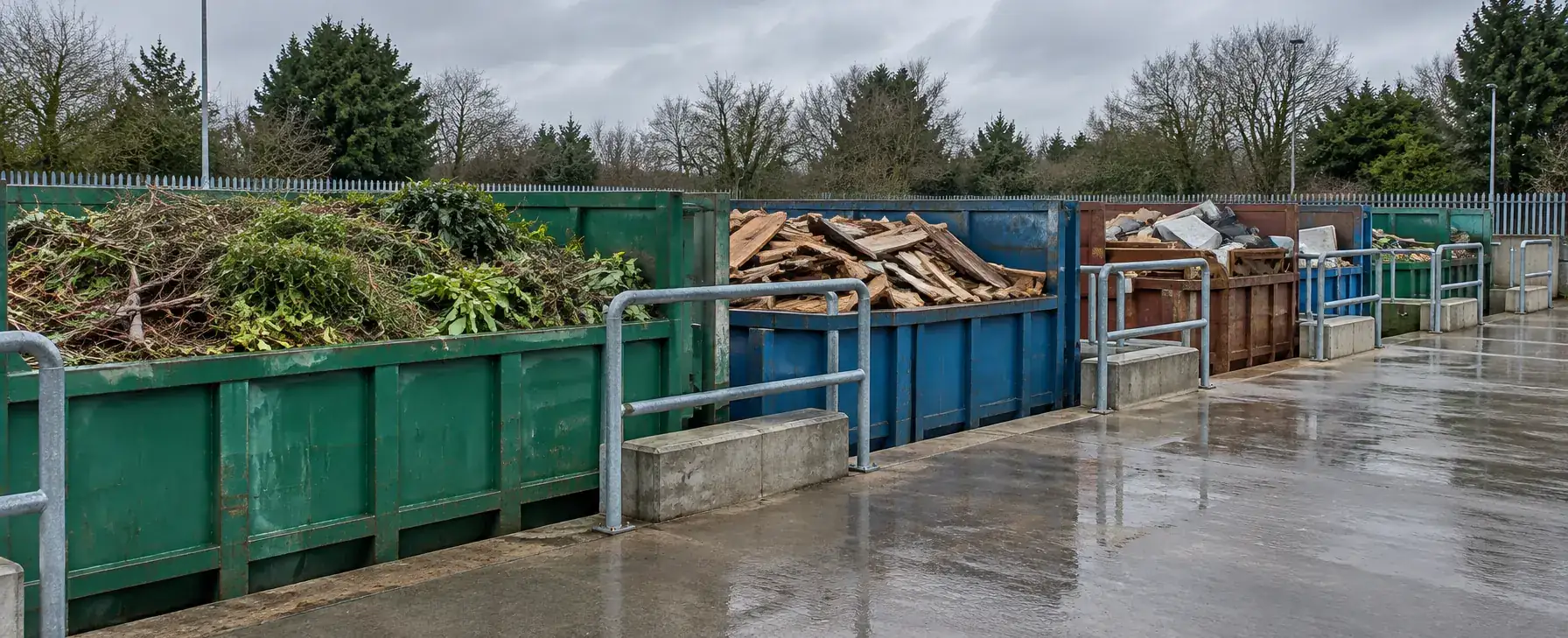 Open skips at a recycling centre holding scrap timber and garden waste